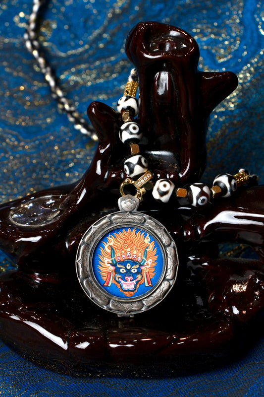 A sacred hand-painted Yamantaka Buddha Head Thangka pendant from Tibet, featuring the wrathful wisdom deity in a silver Three Rabbits case.