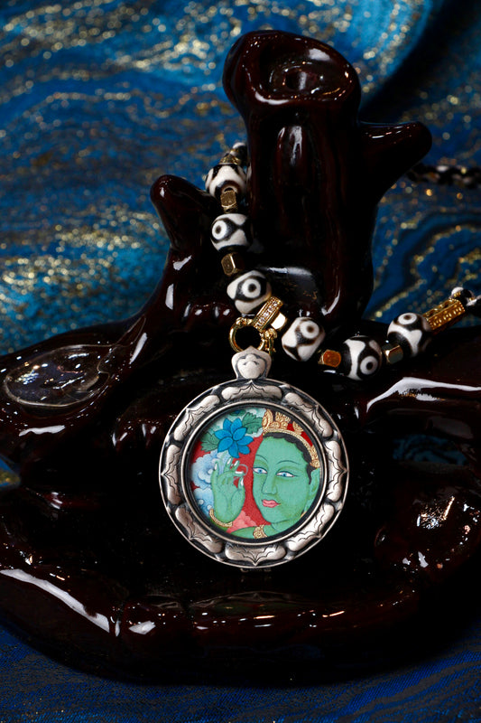 A sacred hand-painted Green Tara Buddha Head Thangka pendant from Tibet, featuring the Goddess of Mercy in a silver Three Rabbits case.