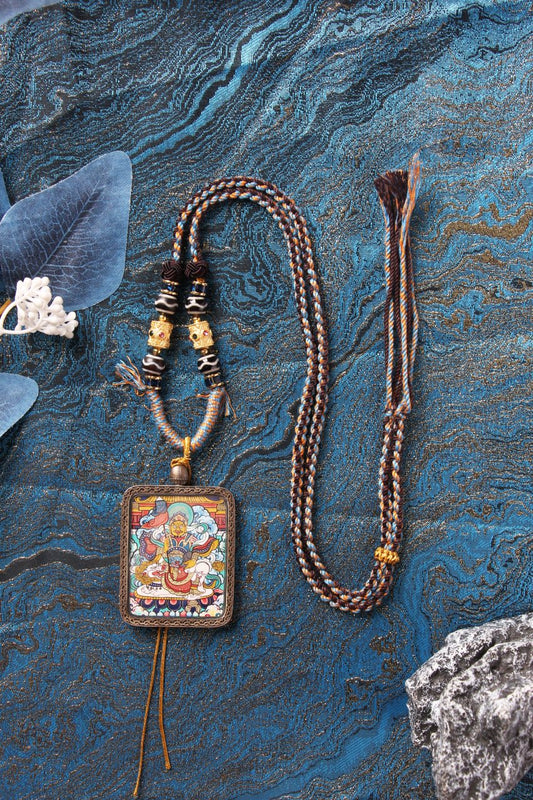 A sacred Rebgong Thangka pendant paired with a traditional hand-woven Tibetan bead necklace for spiritual protection.