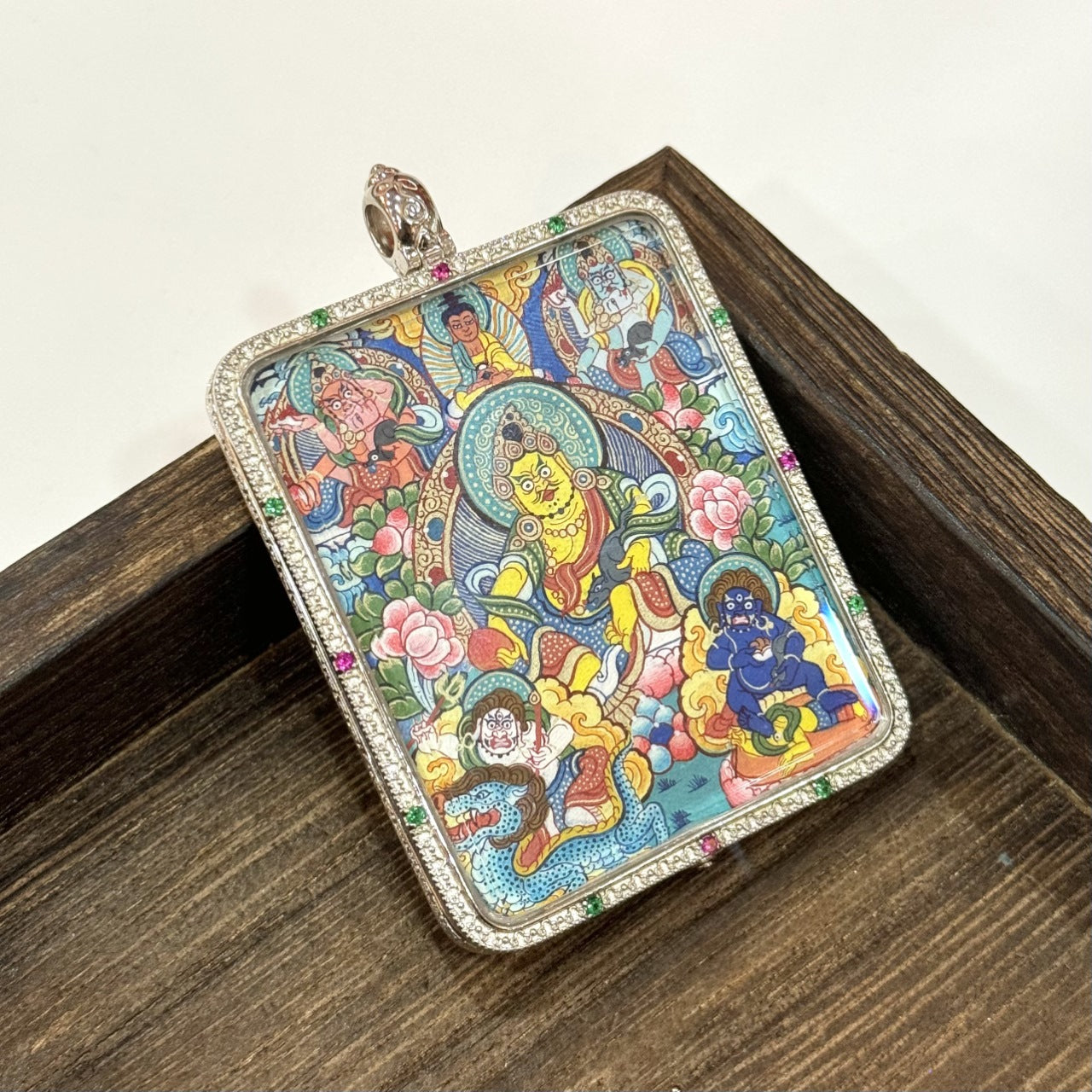  The Rebgong Five Directional Wealth Deities Thangka pendant displayed as a sacred amulet for wealth and merit, embodying Tibetan Buddhist tradition.

