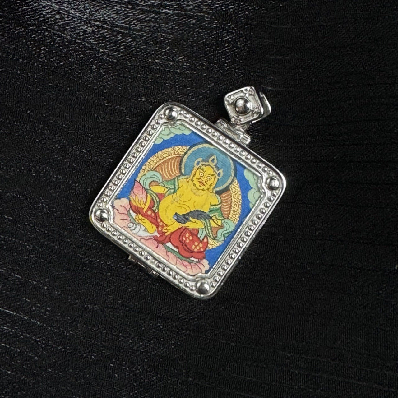  The Rebgong Small Card Yellow Jambhala Thangka pendant displayed as a sacred amulet for wealth and prosperity, embodying Tibetan Buddhist tradition.
