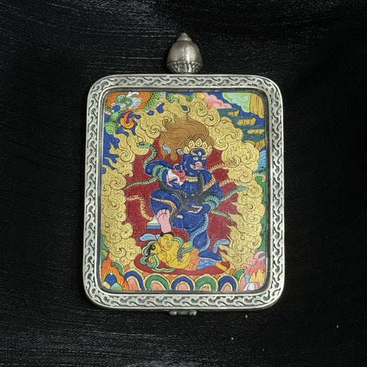 The Tibet Bold Black Jambhala Thangka pendant displayed as a sacred amulet for wealth and protection from petty people, embodying Tibetan Buddhist tradition.
