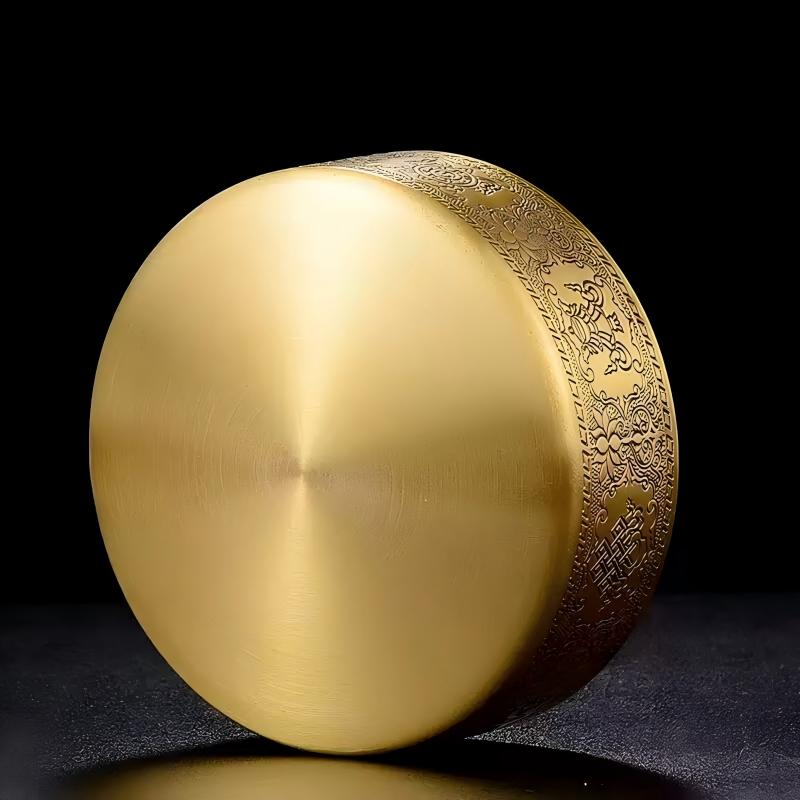 Tibetan Buddhist sacrificial implements culture: Close-up of a hand-engraved copper mandala showcasing exquisite Buddhist sacrificial items art and Himalayan craftsmanship. 