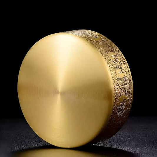 Tibetan Buddhist sacrificial implements culture: Close-up of a hand-engraved copper mandala showcasing exquisite Buddhist sacrificial items art and Himalayan craftsmanship. 