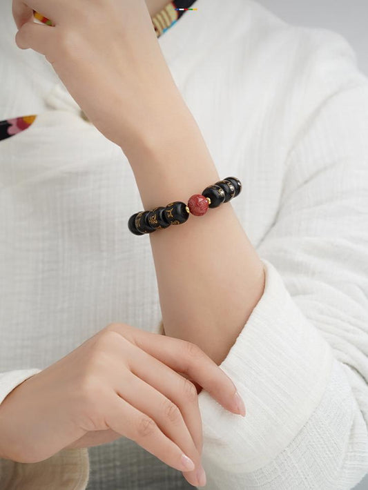 Unique hand-painted ebony and red sand bead bracelet, embodying the essence of Tibetan Buddhist jewelry art.