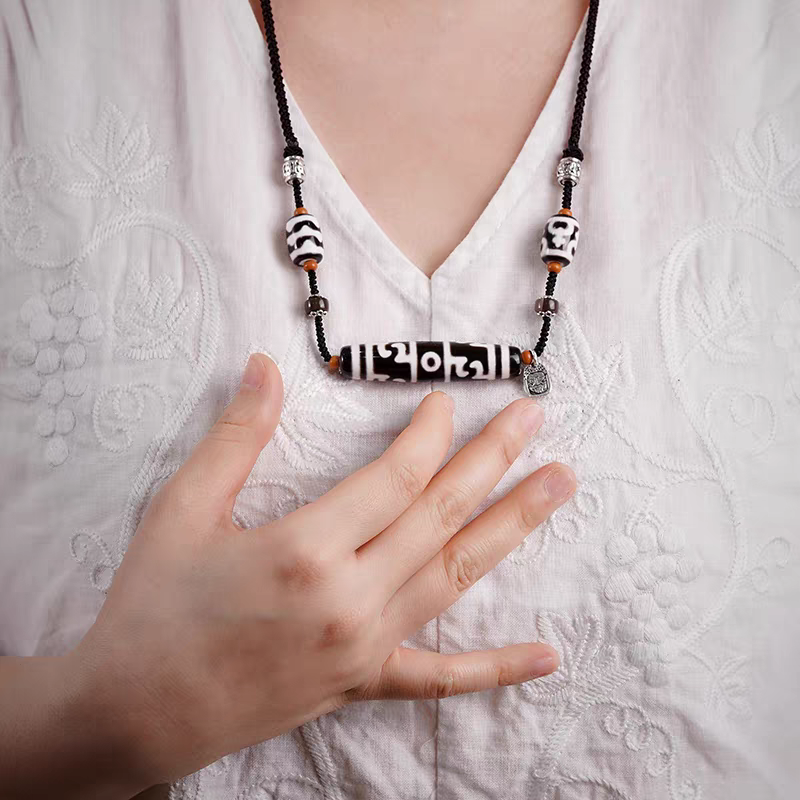 Authentic black and white Lotus Guru Dzi bead, showcasing exquisite jewelry art and Tibetan Buddhist Jewelry Culture. Purely handmade.
