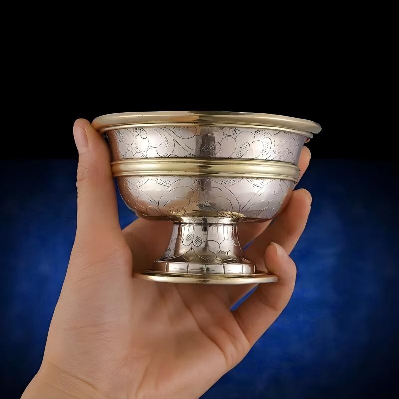 Intricate hand-carved Buddhist water bowl, showcasing artisan jewelry art inspired by the sacred traditions of Tibetan Buddhist Jewelry Culture.