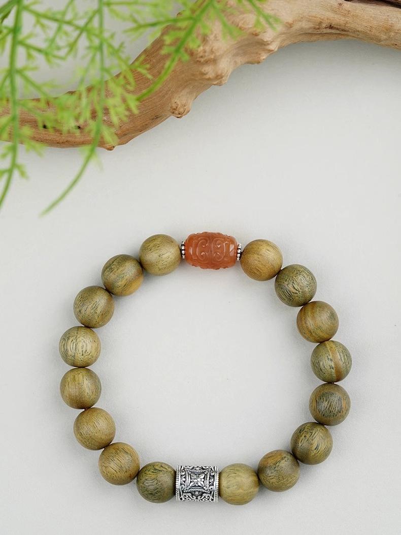 Tibetan Buddhist Jewelry Art: Green Sandalwood Sandalwood Meditation Bracelet featuring traditional Tibetan Buddhist motifs