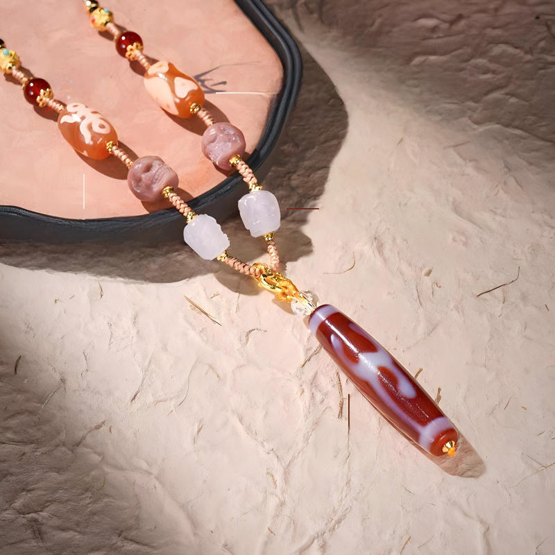Authentic handmade red meat agate Green Tara Dzi bead pendant, showcasing jewelry art and Tibetan Buddhist Jewelry Culture.