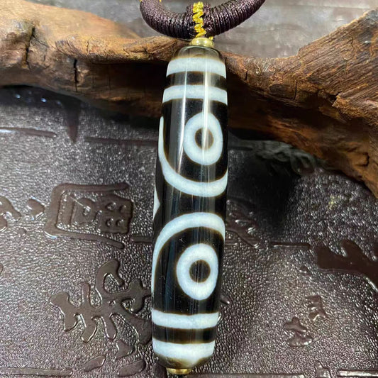 Handmade Nine-Eye Dzi bead necklace pendant, unisex Tibetan Buddhist jewelry art, symbolizing good fortune, protection, and spiritual balance.