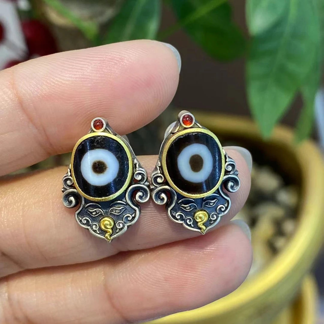 Exquisite handcrafted silver earrings featuring Yellow Jambhala and Green Tara Zhakiram designs, symbolizing prosperity and protection in Tibetan Buddhist jewelry art.