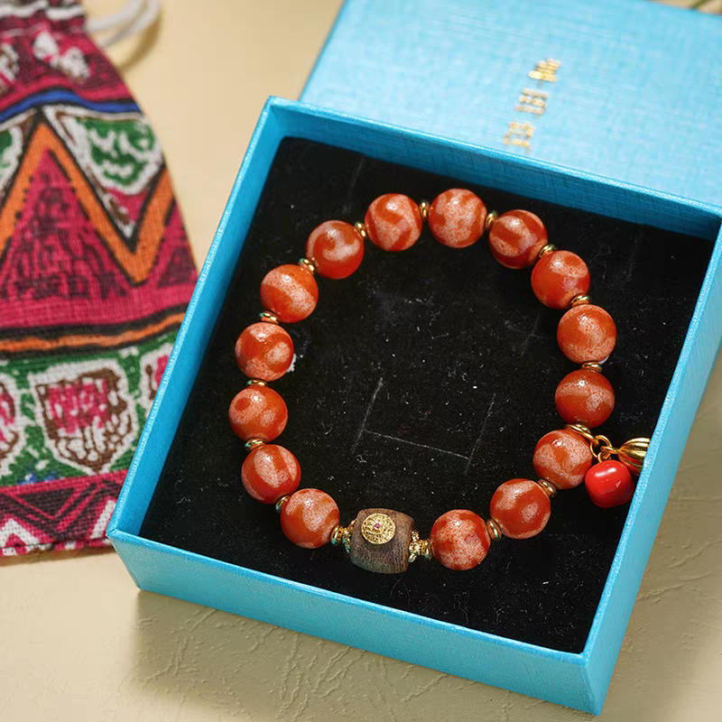 Handmade Red Darlo Dzi beads bracelet, promoting spiritual balance, wealth, and positive energy in Tibetan Buddhist jewelry art.