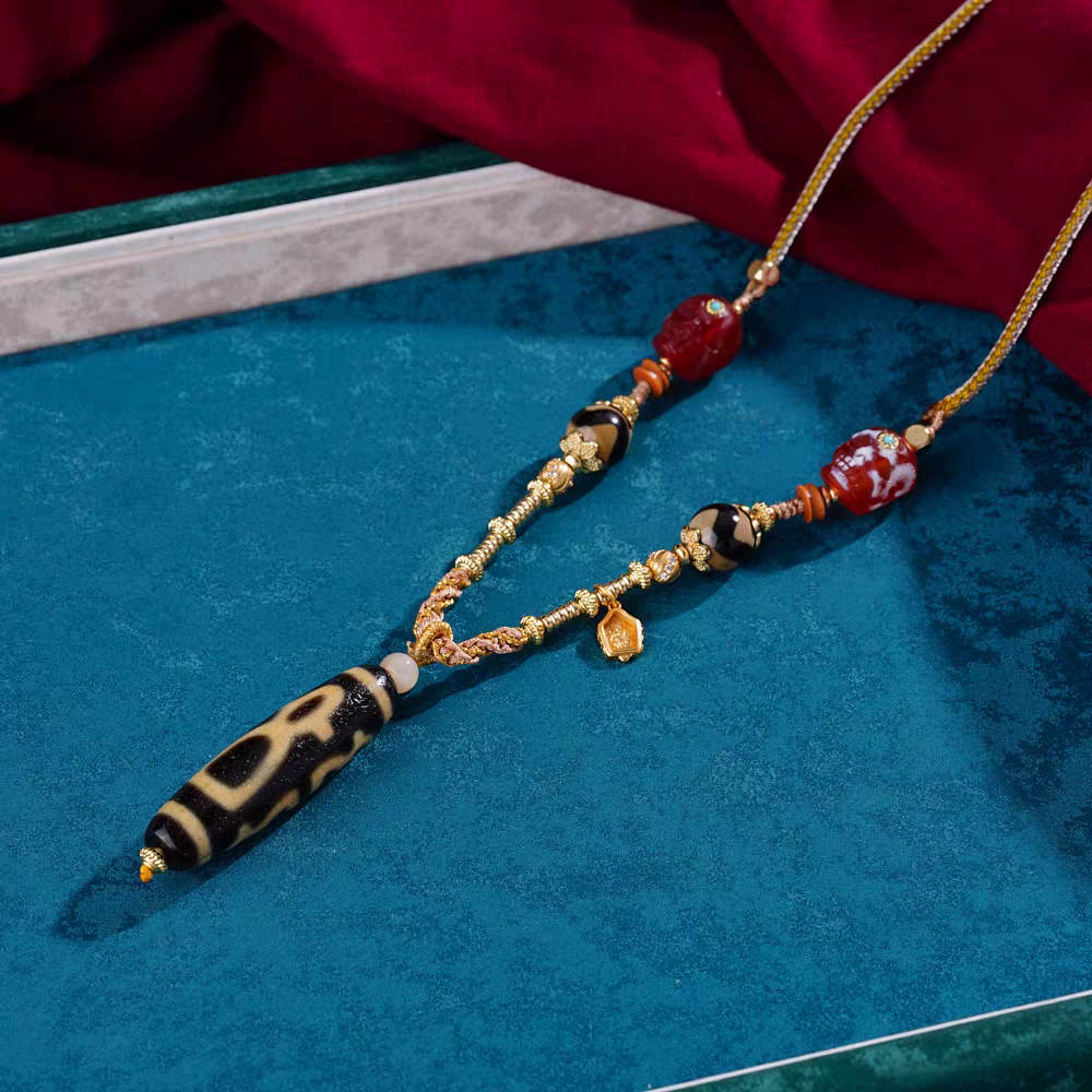 Handcrafted jewelry art pendant featuring the five wealth gods, representing abundance and prosperity in Tibetan traditions.