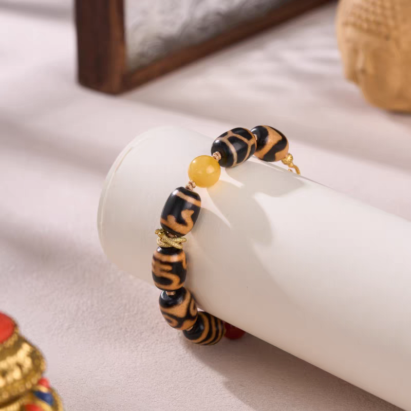 Handcrafted jewelry art bracelet featuring orange meat agate bucket beads, representing wealth and stability in Tibetan traditions.
