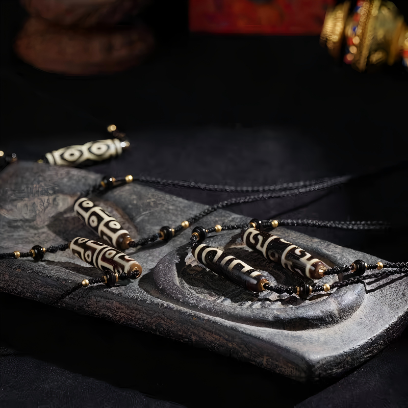 Handcrafted jewelry art pendant featuring a sacred nine-eyed Dzi bead, representing the "King of Dzi" in Tibetan traditions.