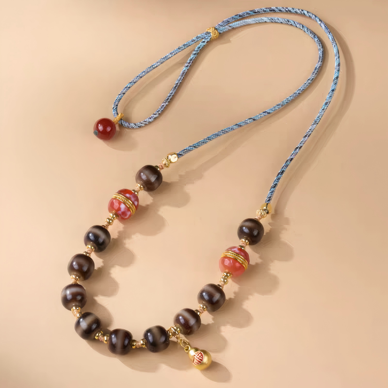 Handcrafted jewelry art necklace featuring a sacred single-line Dzi amulet, representing focus and protection in Tibetan traditions.
