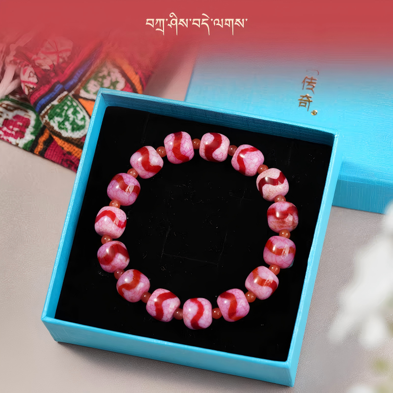 :Handmade Red Agate Zhoma bracelet with Tiger Three-Eye Dzi beads, promoting wealth, luck, and spiritual protection in Tibetan Buddhist jewelry art.