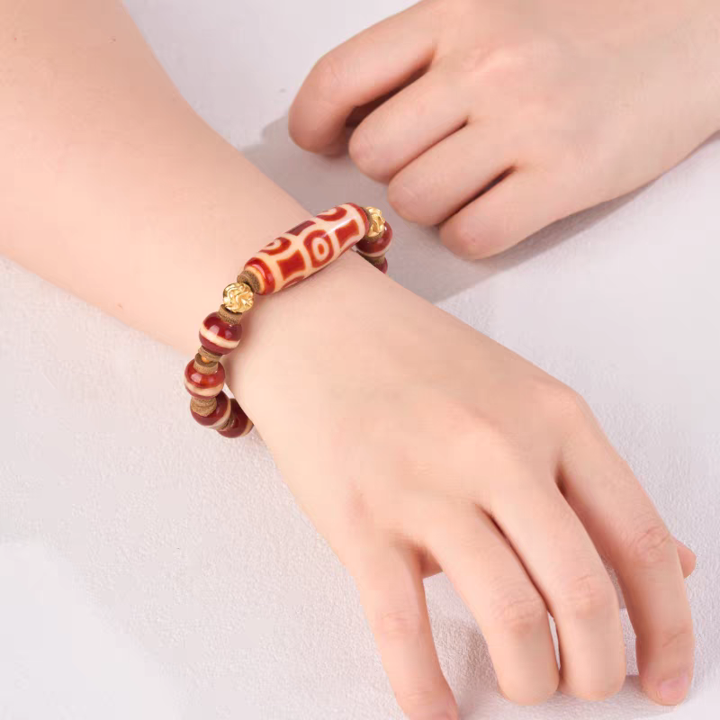 Natural red mutton six-eye Dzi bead bracelet inspired by Tibetan Buddhist jewelry culture, handcrafted to enhance fortune, protection, and mindfulness.