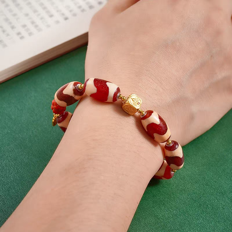 Natural red mutton tiger fang Dzi bead bracelet inspired by Tibetan Buddhist jewelry culture, handcrafted to enhance fortune, protection, and mindfulness.