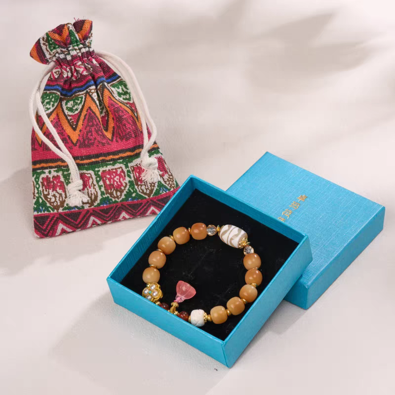 Twin tiger Dzi beads and agate bracelet, handcrafted in Tibetan Buddhist jewelry culture, offering protection and good fortune.