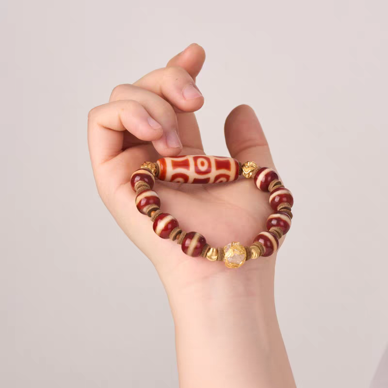 Handcrafted unisex red mutton six-eye Dzi bead bracelet, Tibetan Buddhist jewelry art piece for attracting luck, protection, and positive energy.