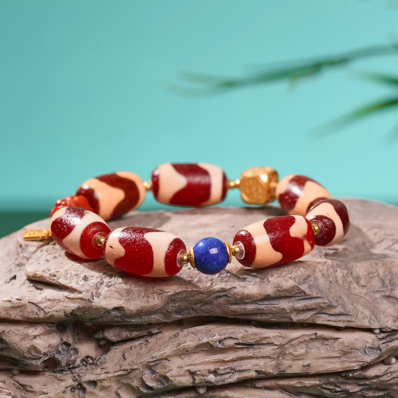Handcrafted unisex red mutton tiger fang Dzi bead bracelet, Tibetan Buddhist jewelry art piece for attracting luck, protection, and positive energy.