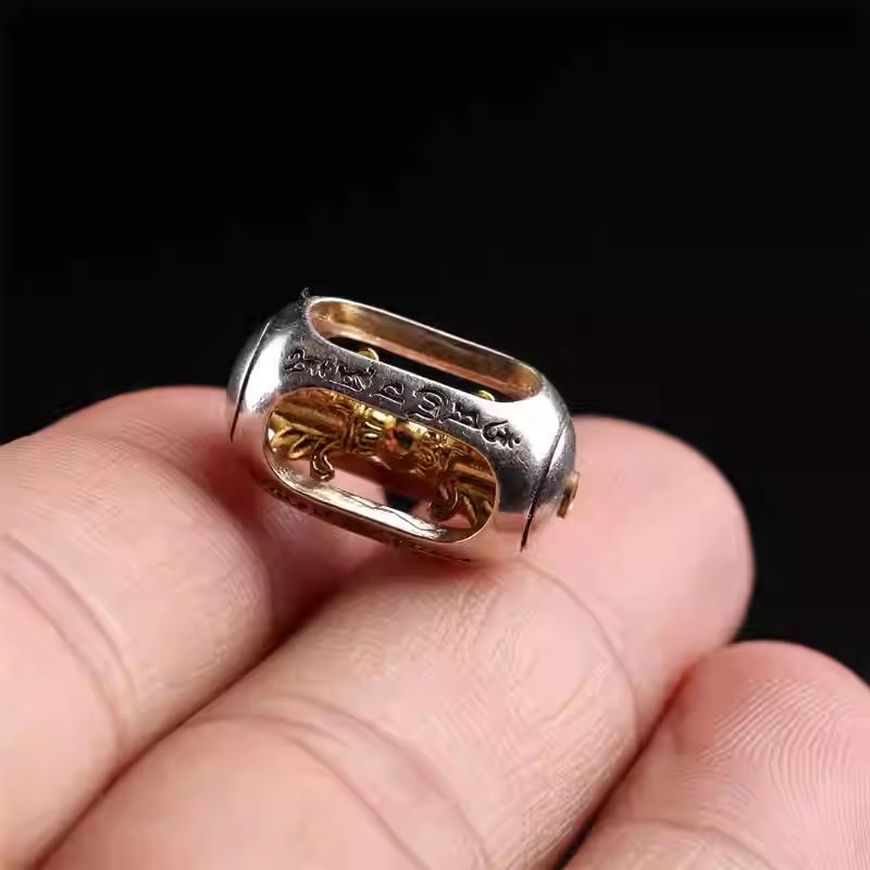 Artisan-crafted spinning silver and copper Vajra amulet, showcasing the dynamic mastery of Tibetan Buddhist Jewelry Culture jewelry art.
