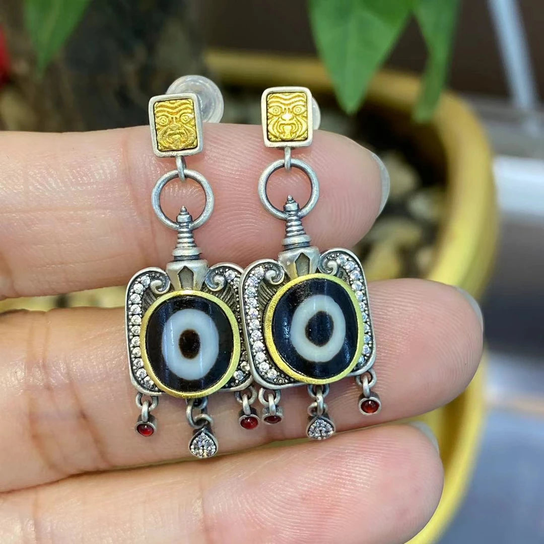 Unique handmade silver Yellow Jambhala and Green Tara Zhakiram stud earrings, reflecting Tibetan Buddhist symbolism and designed to enhance spiritual well-being and fortune.
