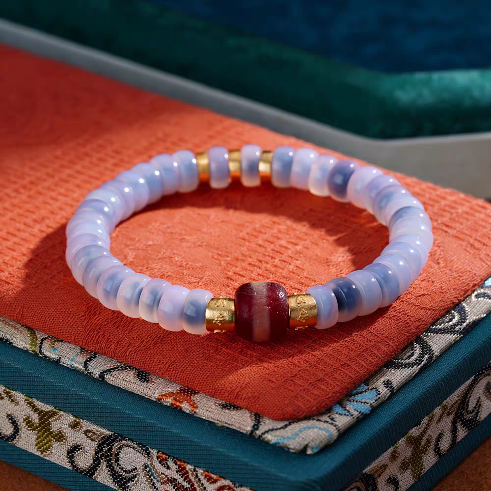 Traditional micro-painted natural agate Medicine Dzi bracelet in blue bubble style, reflecting the profound heritage of Tibetan Buddhist Jewelry Culture jewelry art.
