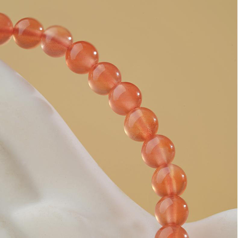 Detail of Pure Handmade Southern Red Cinnabar Beads. Shows artisan hand-polishing and stringing process, each red jasper and cinnabar bead carefully selected for vibrant color and pure energy.