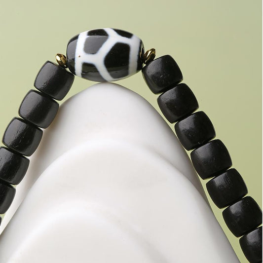 Detailed view of multi-strand sandalwood beads intertwined with hand-painted agate beads, a masterpiece of Tibetan Buddhist Jewelry Art. Explore the craftsmanship and spiritual significance of this unique bracelet.