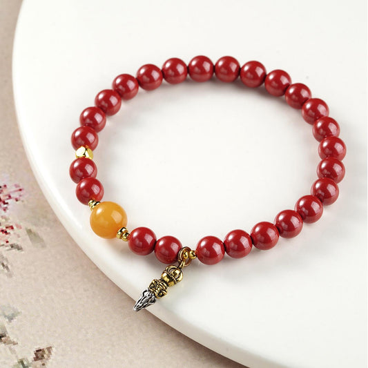 Prosperous Year Cinnabar and Amber bracelet in Tibetan Buddhist jewelry art, featuring hand-painted auspicious symbols for wealth and abundance.