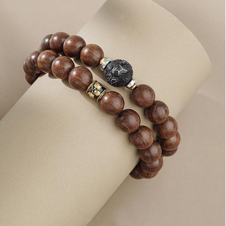The Long Serenity handmade sandalwood spiritual bracelet displayed in a tranquil setting. Paired with scriptures and incense, it creates a serene atmosphere that highlights the detachment and ease it brings.