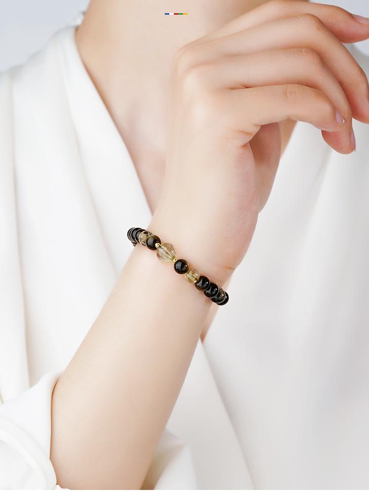 Golden Sheen Obsidian bracelet channeling lunar energy through Tibetan Buddhist jewelry art traditions and craftsmanship.