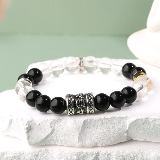 Main product image of Hand-Painted Obsidian and Crystal Bracelet. Features natural obsidian and clear quartz beads in alternating pattern, each bead adorned with artisan hand-painted Tibetan motifs, showcasing the energy balance beauty of Tibetan Buddhist jewelry art.