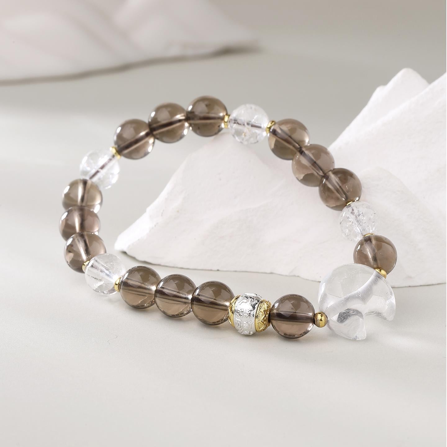 Smoky Quartz and Clear Crystal bracelet in Tibetan Buddhist jewelry art, featuring hand-painted sacred symbols for grounding and clarity in meditation practice.