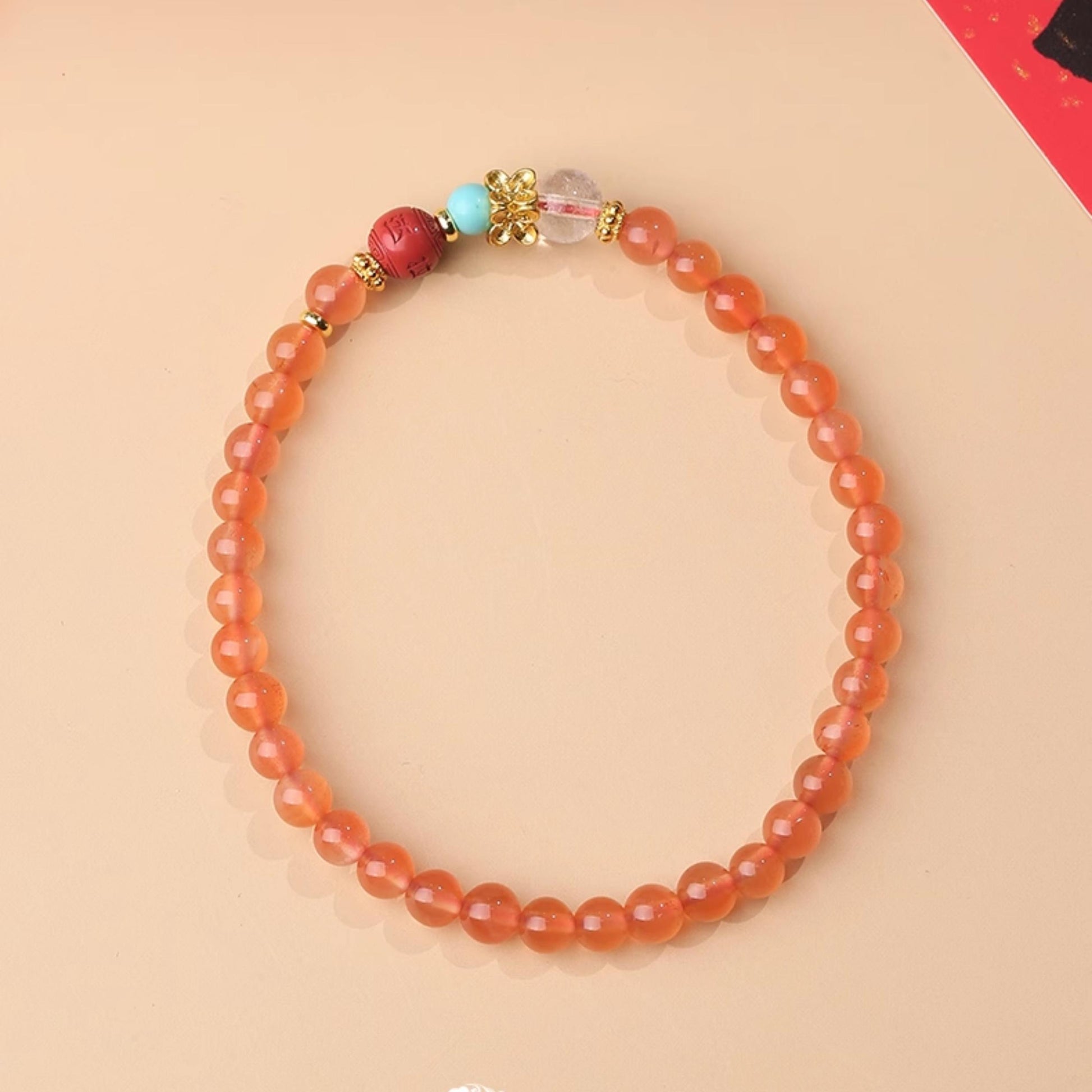 Mantra-Infused Red Queens Jasper Bracelet detail. Each bead contains hand-painted Tibetan scripture, integrating sacred blessings into jewelry art, providing continuous spiritual protection for wearer.