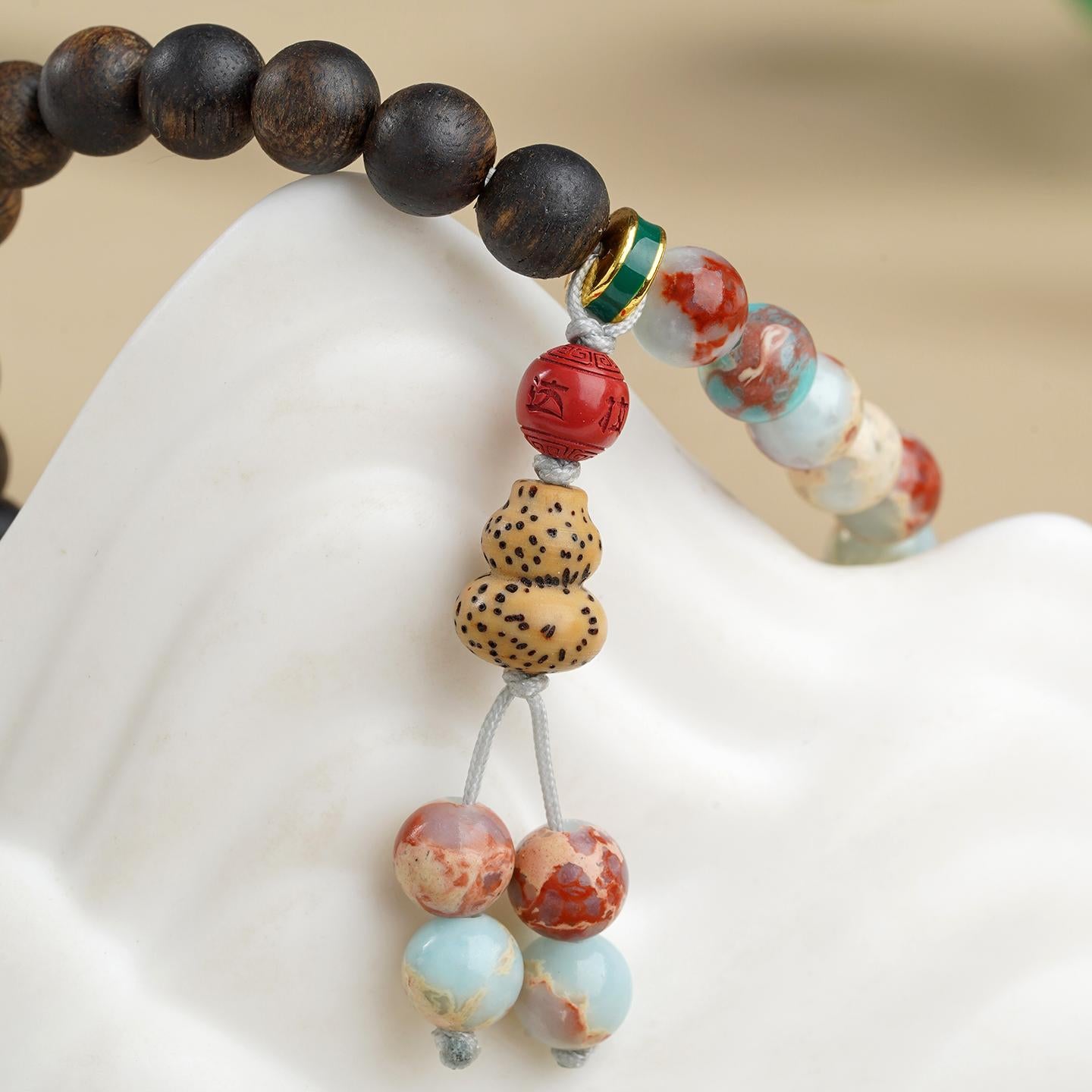 Hand-painted Longevity Stone bracelet with Agarwood accents, embodying Tibetan Buddhist jewelry art for meditation and mindfulness practice.