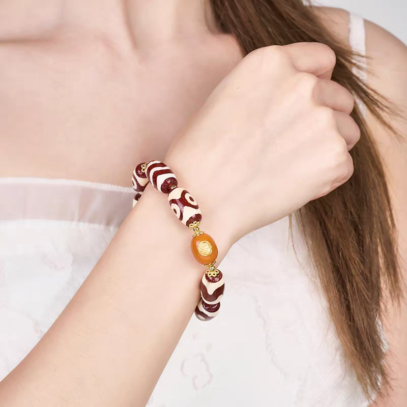 Authentic natural red agate multi-totem Dzi jewelry. This spiritual piece showcases the intricate beauty of Tibetan Buddhist sacrificial implements culture and craft.