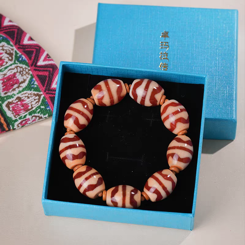 Authentic double tiger tooth Dzi bead bracelet in red meat agate, showcasing Buddhist sacrificial items art and Tibetan Buddhist sacrificial implements culture. Purely handmade.