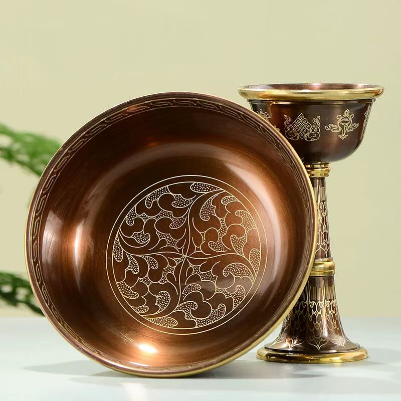 Tibetan Buddhist sacrificial implements culture: Detailed view of hand-engraved copper cups showcasing exquisite Buddhist sacrificial items art and traditional Himalayan craftsmanship.
