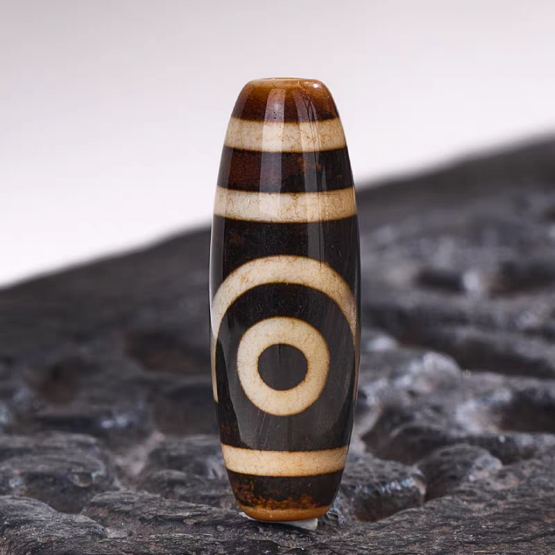 Exquisite ivory yellow natural agate two-eyed Dzi jewelry, a spiritual artifact rooted in Tibetan Buddhist sacrificial implements culture for wisdom and fortune.