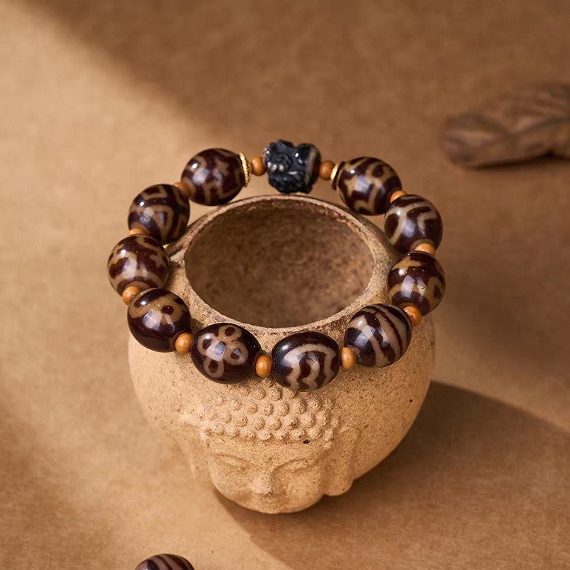 Handcrafted ivory yellow Darlok Dzi bracelet representing comprehensive achievement in Buddhist sacrificial items art and ancient traditions.
