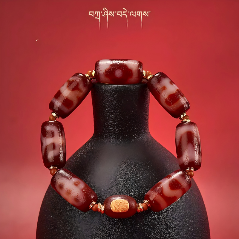 Exquisite tube-shaped natural red agate multi-totem Dzi jewelry, a spiritual artifact rooted in Tibetan Buddhist sacrificial implements culture.