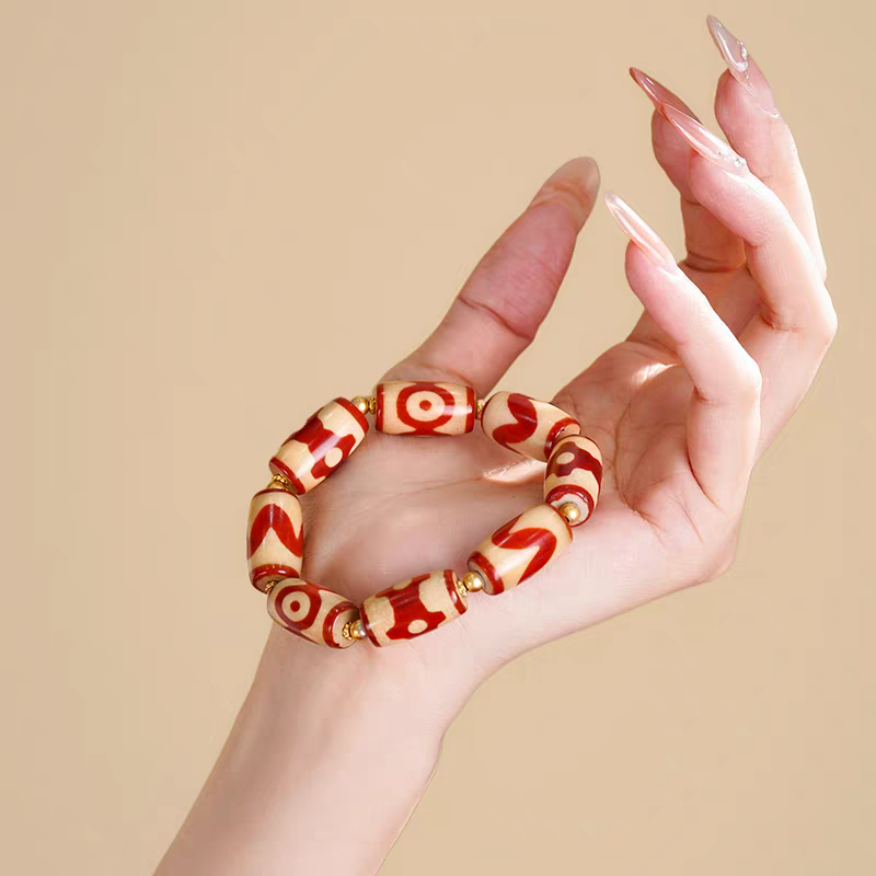 Exquisite mini tube-shaped natural red agate Dzi jewelry, a spiritual artifact rooted in Tibetan Buddhist sacrificial implements culture and craft.