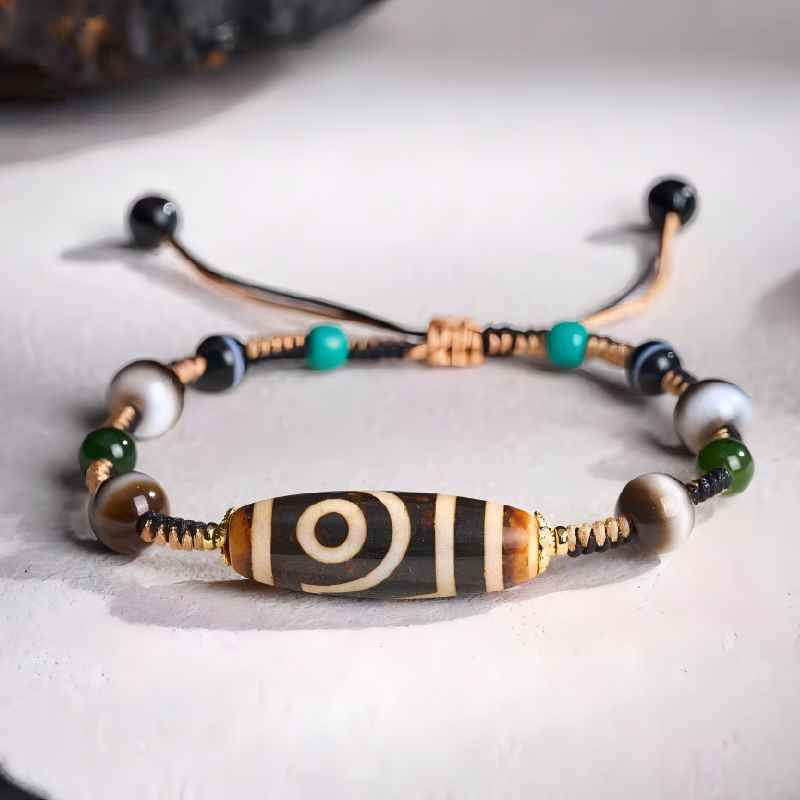 Handcrafted ivory yellow two-eye Dzi bracelet representing balance and harmony in Buddhist sacrificial items art and ancient traditions.