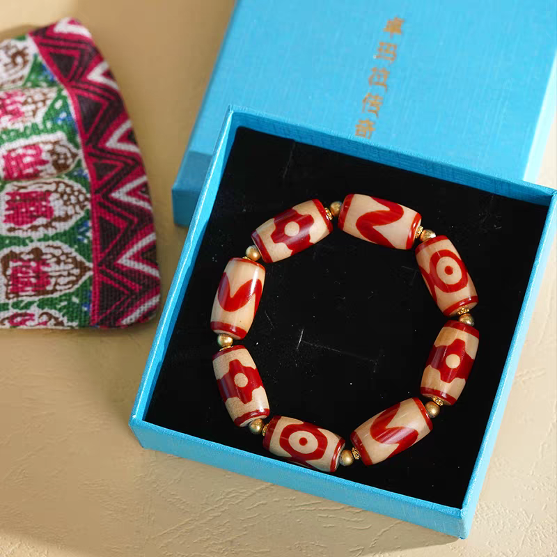 Handcrafted small red meat Dzi bracelet with bucket beads, representing a blend of Buddhist sacrificial items art and ancient traditions.