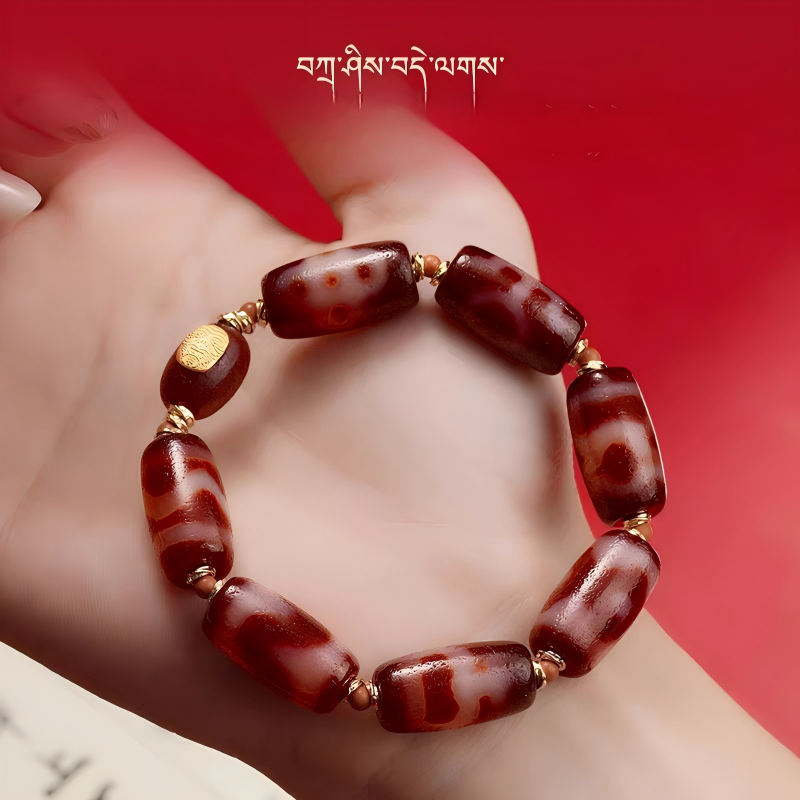 Handcrafted red Dzi bracelet with bucket beads, representing a blend of Buddhist sacrificial items art and ancient Tibetan Buddhist sacrificial implements culture heritage.