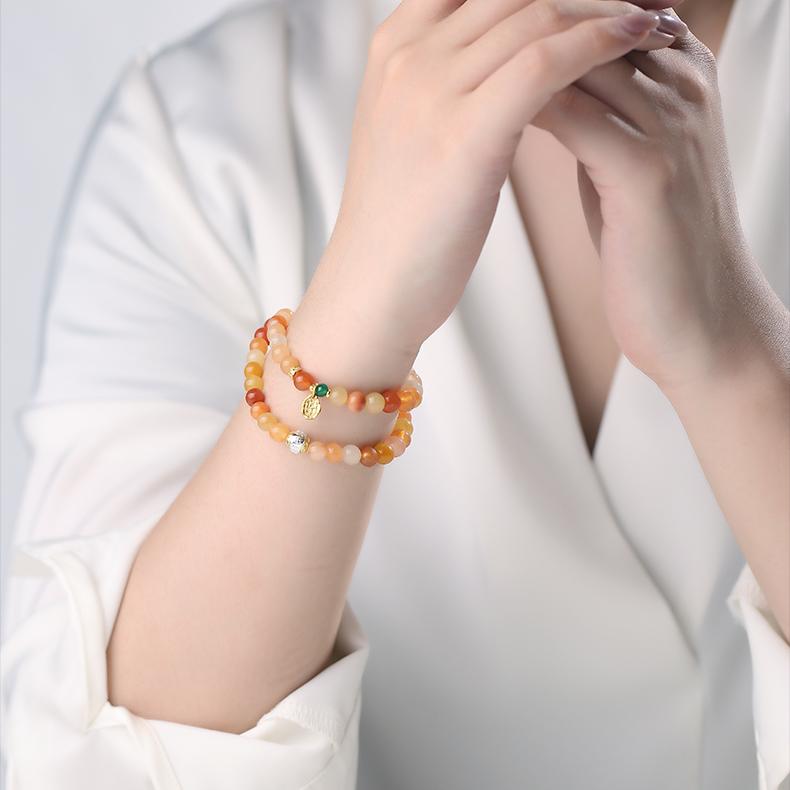 A unique multi-layer bracelet featuring golden silk jade and sandalwood. Handmade with Tibetan Buddhist craftsmanship to bring balance, peace, and prosperity.