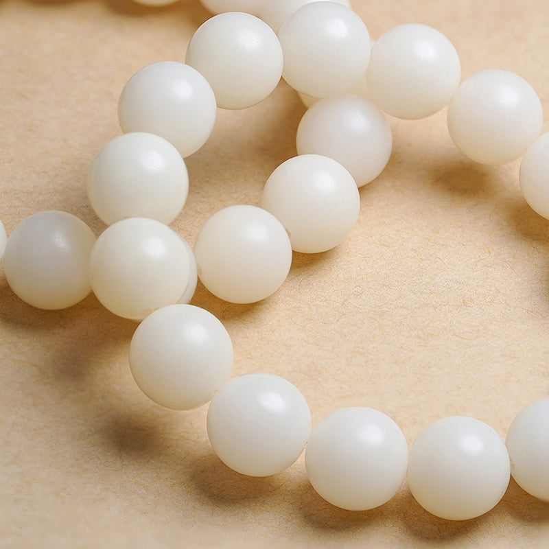 White Bodhi Enlightenment jewelry with 12mm wood beads and sacred carvings. This Tibetan Buddhist jewelry art promotes spiritual clarity through authentic craftsmanship.